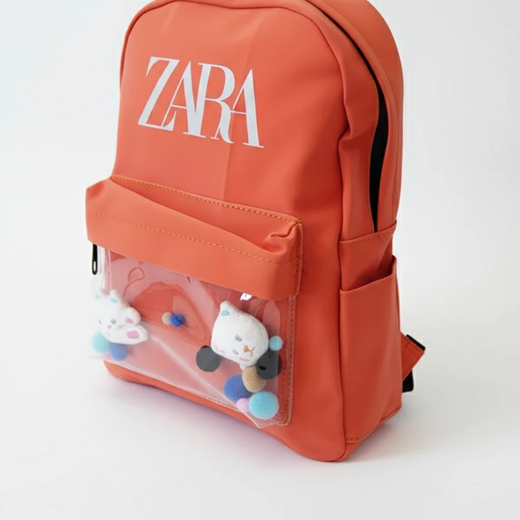 نمای زاویهدار کوله پشتی نارنجی ZARA با جیب جلو شفاف و عروسک تزئینی داخل آن