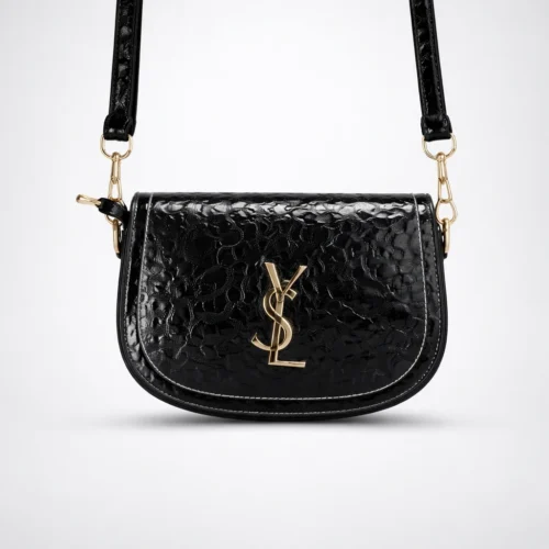 کیف زنانه YSL ورنی مشکی با بافت برجسته براق و لوگوی فلزی طلایی YSL، عکس آتلیه‌ای روی پس‌زمینه روشن