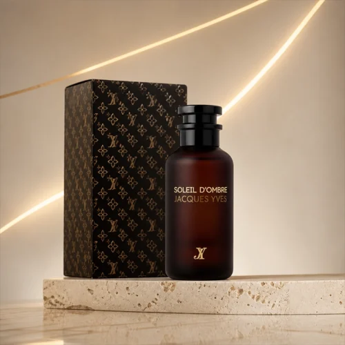 ادکلن Soleil D'Ombre Jacques Yves با بطری تیره و جعبه مشکی طلایی روی پایه سنگی روشن
