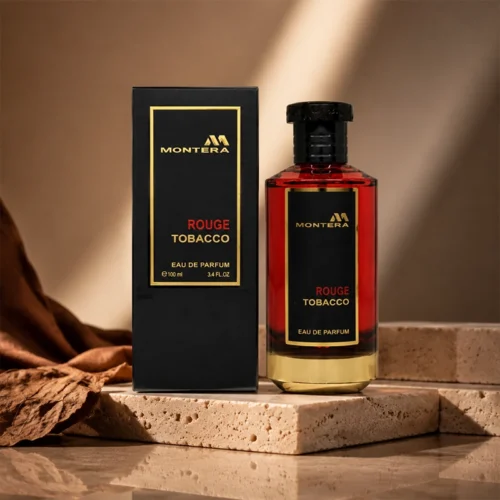ادکلن Montera Rouge Tobacco با بطری قرمز تیره و جعبه مشکی طلایی روی سطح سنگی